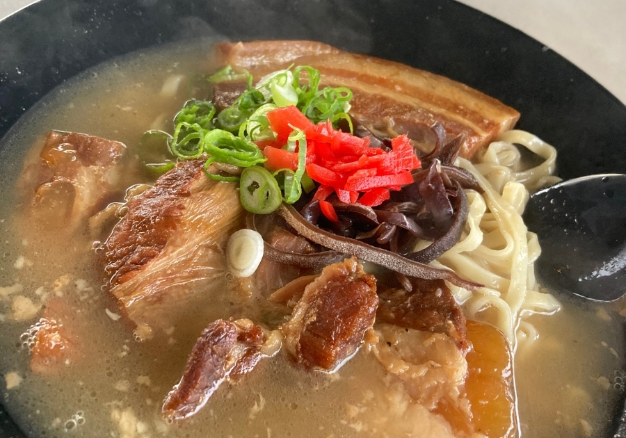 たっちゃんヌードルの沖縄そば。あっさり出汁と豚肉ソーキ、紅生姜、ネギがのった優しい味の伝統的な一杯。