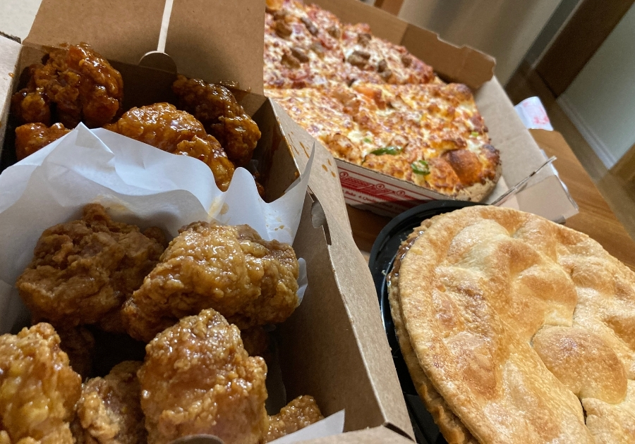 韓国フライドチキンと、ピザとアップルパイが食卓に並ぶ様子。