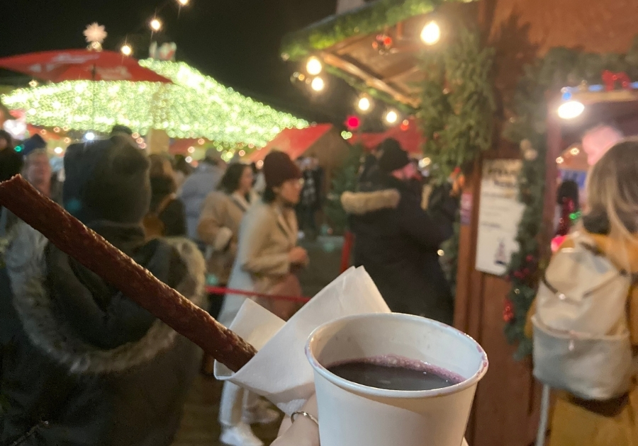 バンクーバーのクリスマスマーケットで飲めるグリューワイン。紙カップに注がれ、サラミスティックが添えられている。