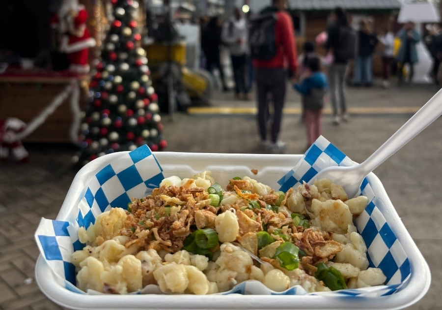 バンクーバーのクリスマスマーケットで食べられるシュペッツレ。チーズとフライドオニオンがかかった温かいパスタ料理。