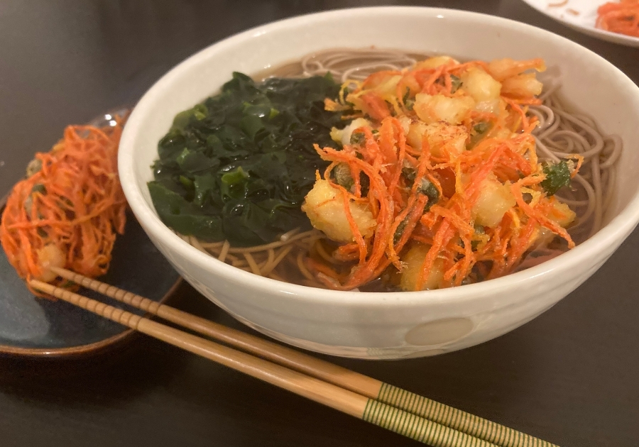 年越しに自宅で作ったそば。えびのかき揚げとわかめをのせた年越しそばと箸。
